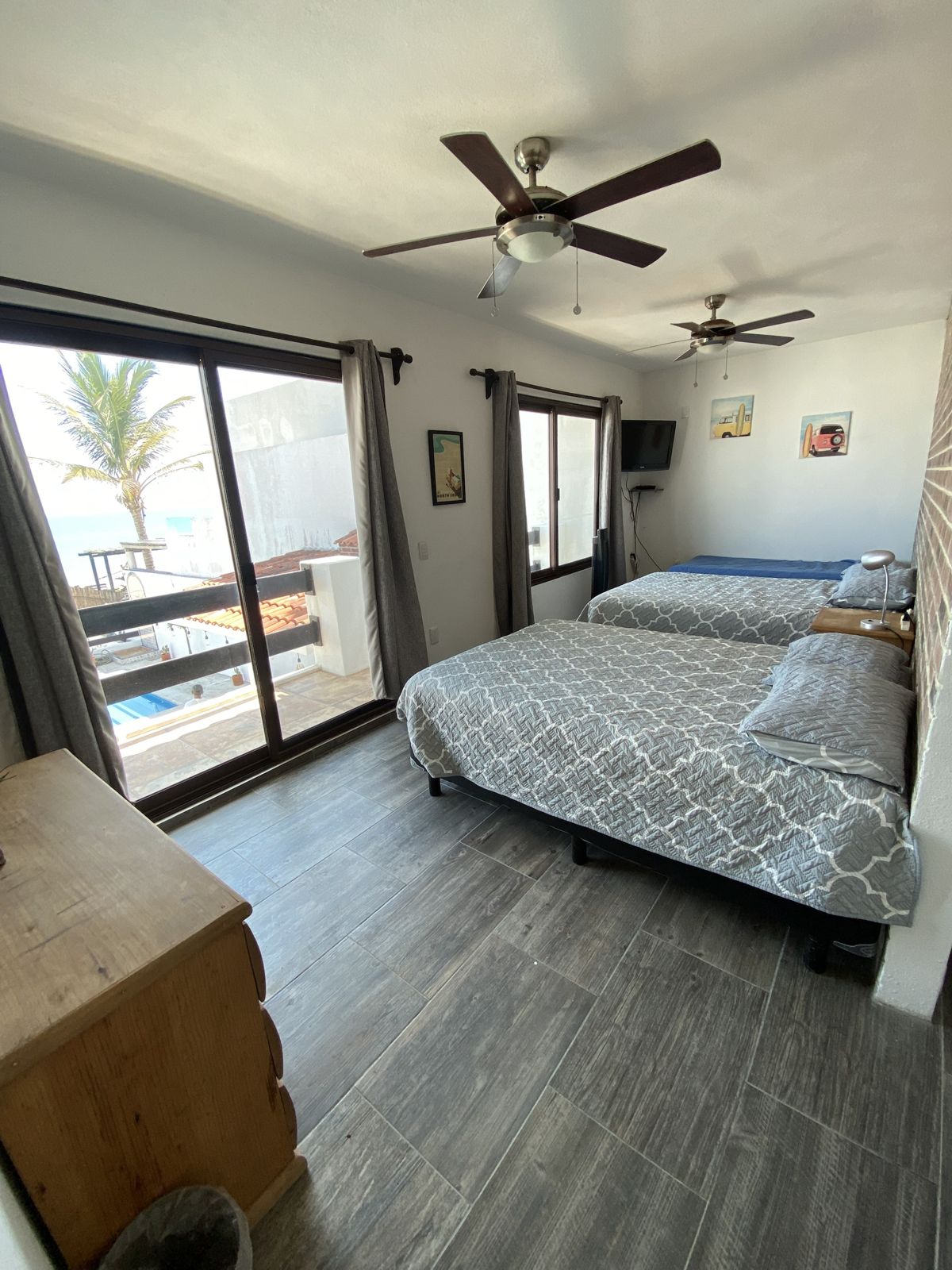 Cuarto compartido con dos camas y ventanal al balcón