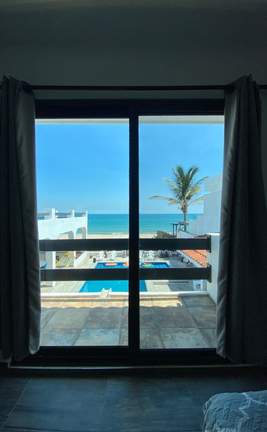 Vista a la alberca y la playa desde el ventanal de la recámara